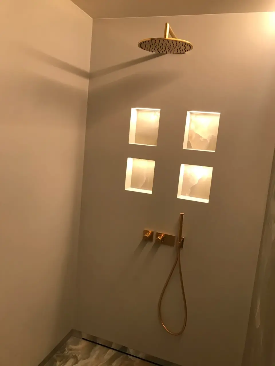 Sprchový kout v šedobéžové stěrce s podsvícenými nikami