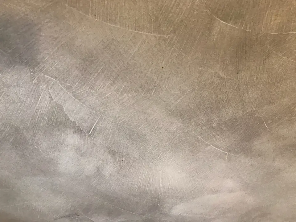 Detail šedé stěrky s oblouky hladítka