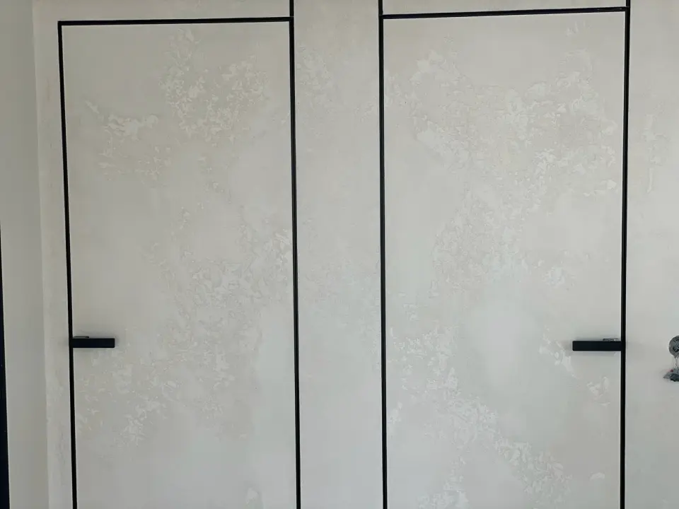 Dvoje skryté dveře ve stěně se světlou stěrkou