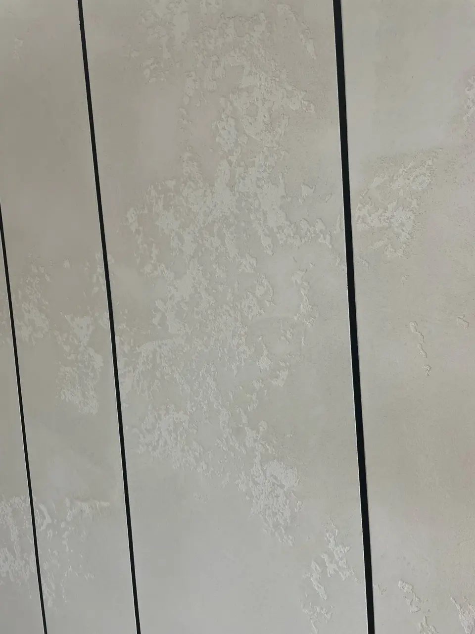 Detail plastické stěrky mezi černými lištami
