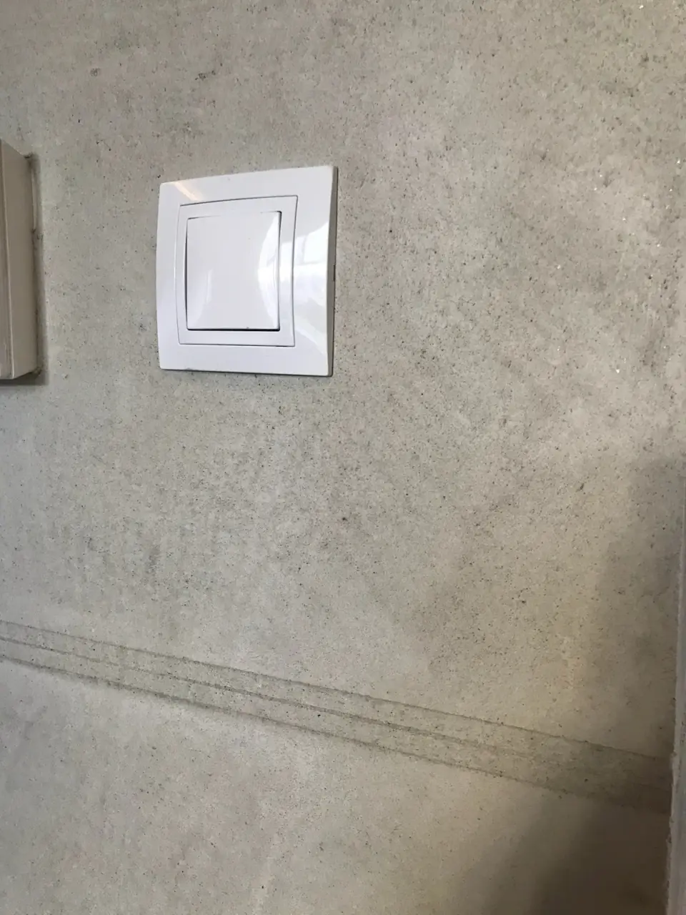 Detail vodorovné drážky ve stěrce v imitaci betonu